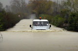 A Land Rover makes its way along a flooded A470 road near Llandrinio