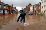 A friend gives his mate a lift through the floods in Newtown Road, Hereford.